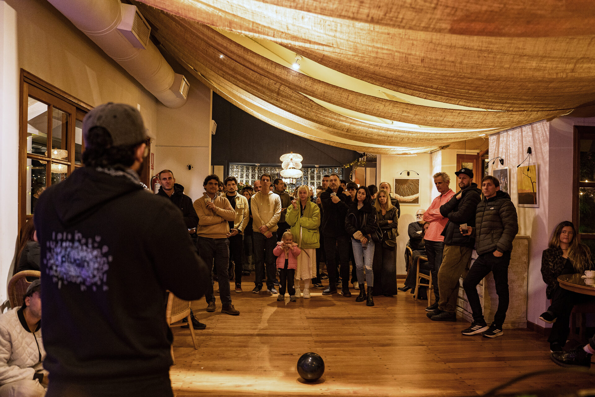 El público escucha de pie una charla abierta en el salón de Este Lugar.